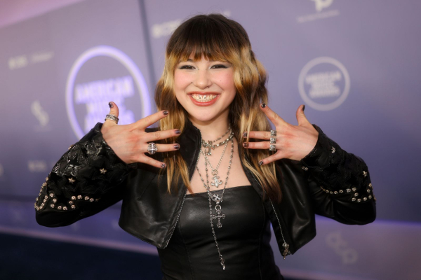 Alysa Liu poses at the AMAs in a black outfit and sheer black nails topped with decals to resemble piercings.